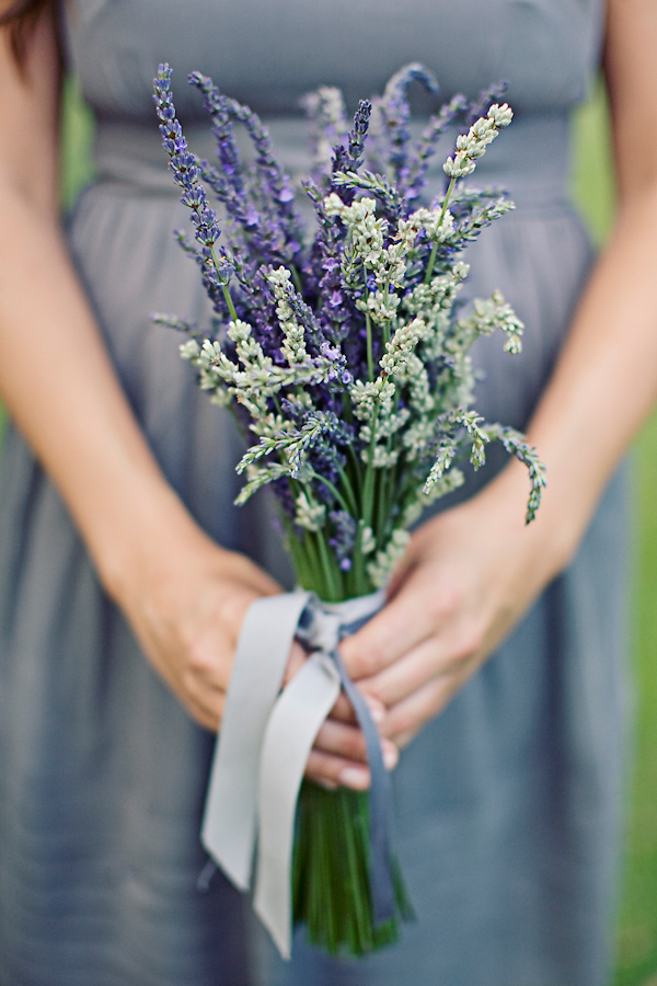 Bridesmaid wearing purple dress and holding bouquet made of lavendar with a lavendar colored ribbon - wedding photo by Meg Perotti